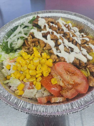 Rice plate with meat, vegetables and garlic sauce.